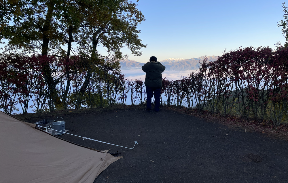 早朝のキャンプサイトから雲海と山並みを眺める様子